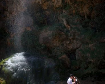 A young couple getting a photo session at the Bridal Veil waterfall during the hot springs tour